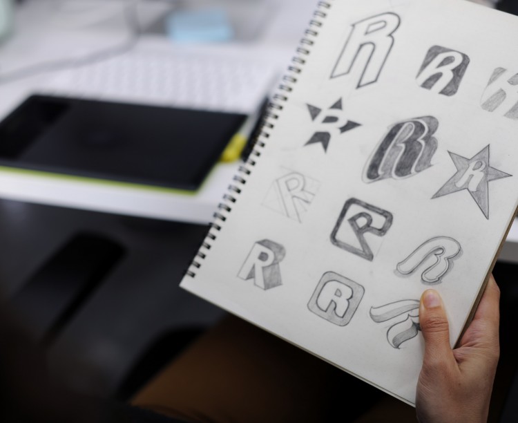 hand-holding-notebook-with-drew-brand-logo-creative-design-ideas-min